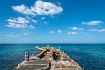 Old pier over blue sea. Havana. Cuba.