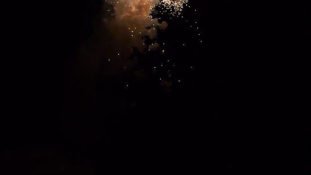 Conceptual shot of a silhouetted man standing in front of a fireworks display, shot in slow motion.