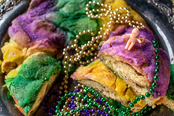 king cake with baby surrounded by mardi gras beads - obrazy, fototapety, plakaty