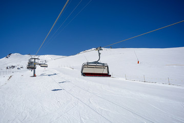 Fototapeta na wymiar Chair Lift in the Alps with sunshine