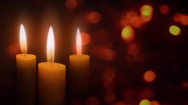 Candles in the Christmas Lights 4K Loop features three holiday candles flickering in an atmosphere of floating diffused lights