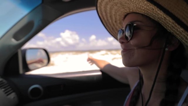 Girl riding in car on beach