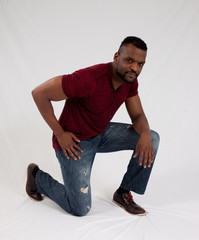 Serious Black man kneeling thoughtfully