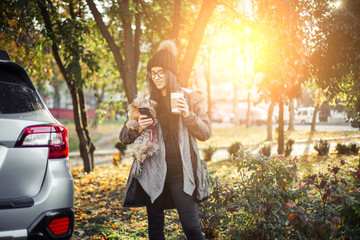 Young woman with puppy dog and coffee walking on street
