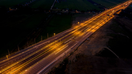 Fototapeta na wymiar long exposure at night freeway traffic car transportation in Thailand aerial top view