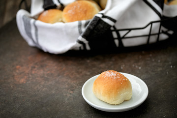 Homemade Dinner Rolls in Bread Basket with One Isolated on Plate