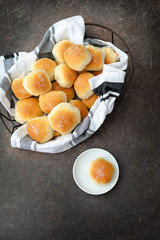 Homemade Dinner Rolls in Bread Basket with One Isolated on Plate