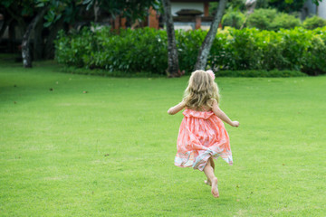 Caucasian little girl is running in a park