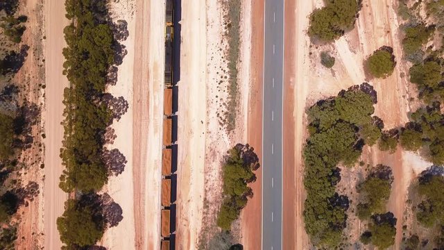 Aerial shot of train driving over railway surrounded by nature environment, drone passing by. Southern Australia.