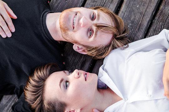 adult boy and girl are lying on the wooden floor