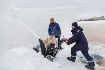 Worker operator snow plow on snow removal