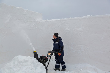 Worker operator snow plow on snow removal