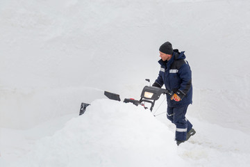 Worker operator snow plow on snow removal