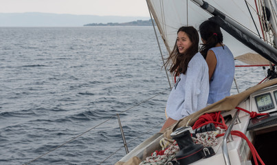 mother and daughter sitting on the deck of a sailboat