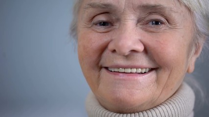 Face close-up of smiling elderly woman, social security, taking care in old age