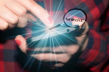 Eine Frau am Smartphone sucht nach Krediten im Internet