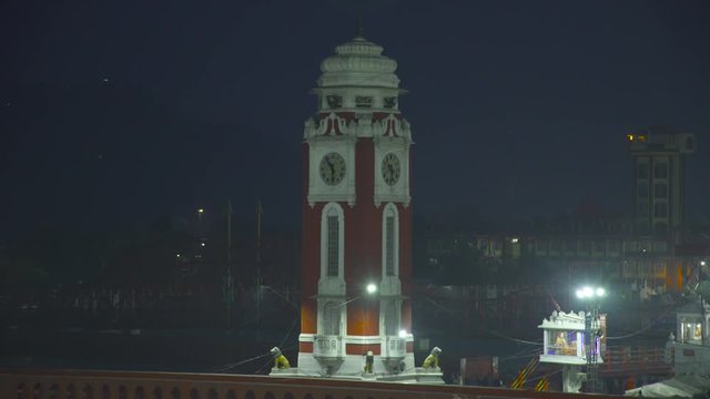 Static shot of Clock Tower,Har ki Pauri, Haridwar, Uttarakhand, India. The River Ganga enters the Gangetic Plain for the first time at Haridwar.Clock tower surrounds by Ganga,pilgrims.