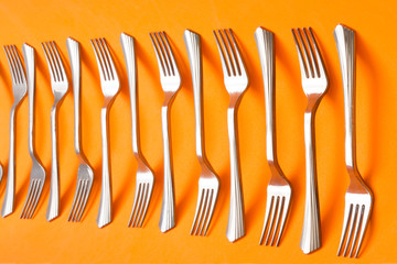 Abstract still life with forks on orange background