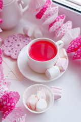 Fototapeta na wymiar Pink breakfast of kawaii japanese girl - scented herbal tea in white cup, candy pink decor, marsmallow sweets, pretty morning tea party