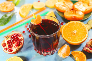 pomegranate juice in a glass on the background of cut citrus fruits.