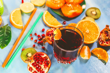 pomegranate juice in a glass on the background of cut citrus fruits.