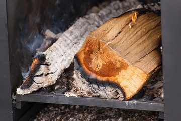 Firewood and carbon in fireplace or smokehouse
