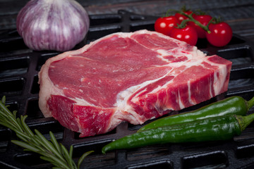  beautiful and juicy raw steak on the table with ingredients ready to roast