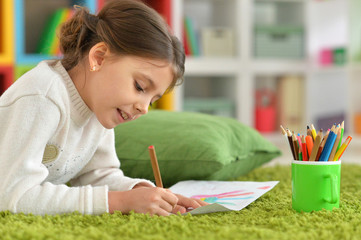 Portrait of cute little girl drawing at home