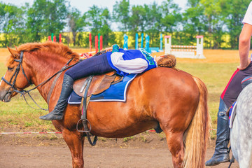 Russia, Samara, August 2018: a Cossack girl lying on a horse above
