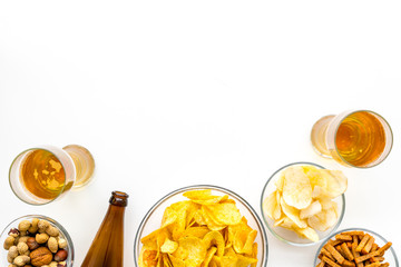 Snacks and beer. Chips, nuts, rusks near beer on white background top view space for text