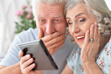 portrait of happy beautiful senior couple using tablet