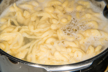 German noodles called Spaetzle cooking in a pot