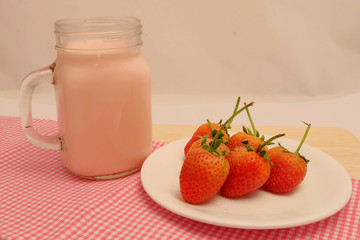 Strawberry and milk straberry flavoron wood table, sweet romantic fruit for special person in special days, lovers in Valentine day, make many dessert menu or juice or dairy strawberry flavor