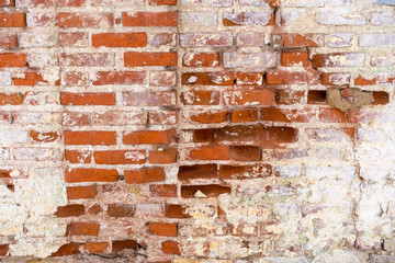 a fragment of an old flaked unrestored brick wall of an orthodoxal church in a small Russian town