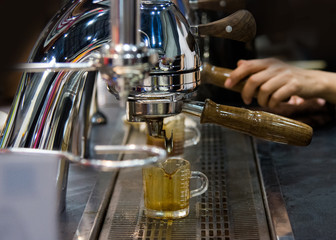 Fototapeta na wymiar Espresso shot from coffee machine in coffee shop,Coffee maker in coffee shop