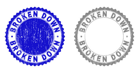 Grunge BROKEN DOWN stamp seals isolated on a white background. Rosette seals with distress texture in blue and gray colors. Vector rubber imitation of BROKEN DOWN title inside round rosette.