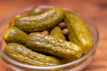 Pickles in the glass jar on the wooden table