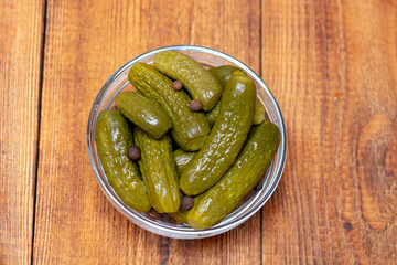 Pickles in the glass jar on the wooden table