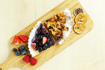 fruit tart with berries and nuts on wood table