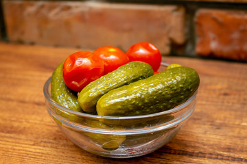 Pickles in the glass jar on the wooden table