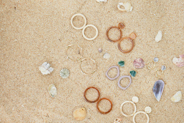 Fototapeta na wymiar Handmade Jewelry on Sand Beach Top Down View