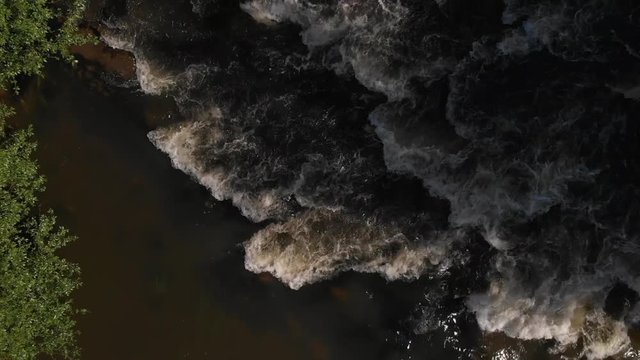 Top Down view moving up fast moving river (Nykopingsan). Nykoping, Sweden. Aerial in slowmotion