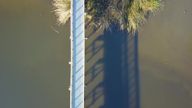 Top down aerial drone shot of boardwalk in-between a lake in Oso Flaco, located on the Central Coast of California, Santa Barbara County