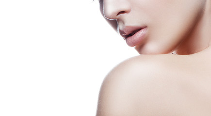 Lips, part of face and shoulder of young model girl with perfect skin, natura; nude make-up. White background. Facial treatment concept