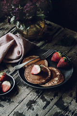 Vegan Banana Pancakes with Strawberries on a Dark Wooden Background