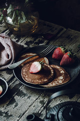 Vegan Banana Pancakes with Strawberries on a Dark Wooden Background