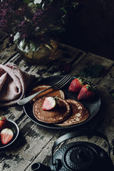 Vegan Banana Pancakes with Strawberries on a Dark Wooden Background