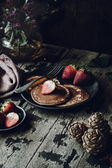 Vegan Banana Pancakes with Strawberries on a Dark Wooden Background