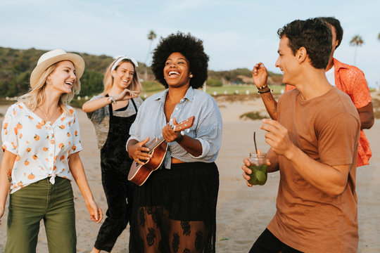 Friends singing and dancing at the beach