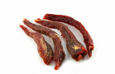 Long sliced of dried meat beef jerky isolated on white on white background